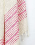 Close-up image of a pink colour with multiple stripes on a plain beige colour.