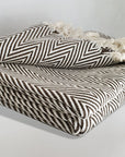 Stylish folded handwoven extra large blanket with a chevron pattern in brown colour.