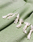 Stylish photo-shooting of a green colour large-size blanket with knotted fringe style.