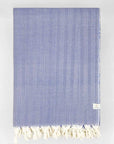 Folded handwoven %100 cotton blanket with a herringbone pattern in blue colour.