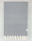 Folded handwoven %100 cotton blanket with a herringbone pattern in grey colour.