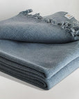 Stylish folded strong cotton blanket with a simple pattern in grey colour.