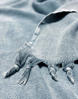 Stylish photo-shooting of a grey colour strong cotton blanket with a knotted fringe.